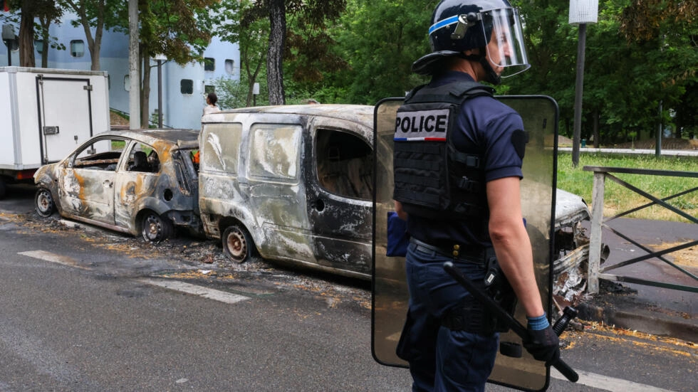 フランスの警察官は、パリ郊外のナンテールで交通停止中にフランスの警察官に撃たれた17歳のティーンエイジャーの死に続いて、抗議者と警察の間の衝突の夜に燃やされた車両の隣で2023年7月1日に見張りをしています。© ロイター / イヴ・ハーマン