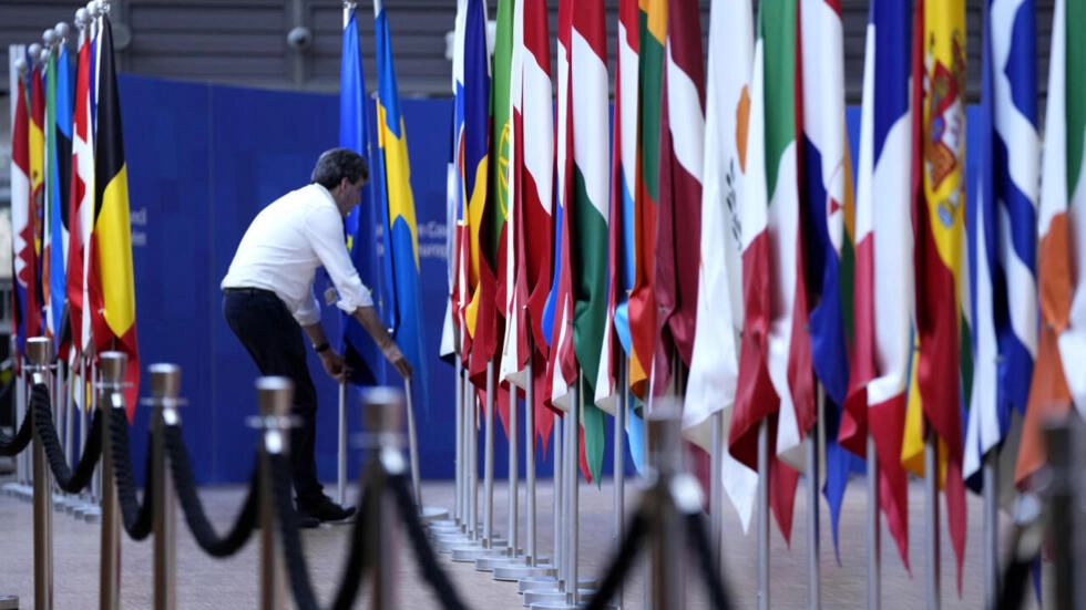 最近のEUサミットの準備中、ある男が欧州連合諸国の旗を動かす。© バージニア・メイヨー / AP