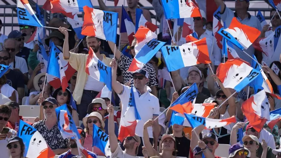 2024年7月29日、フランスのパリで開催された夏季オリンピックで、フランスのファンが旗を振っています。©レベッカ・ブラックウェル/AP