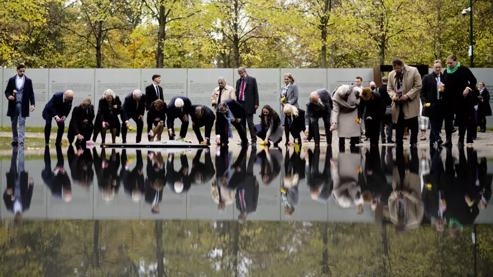 ドイツのフランク=ヴァルター・シュタインマイヤー大統領は、2022年10月24日にベルリンでホロコーストのシンティとロマの犠牲者の記念碑に花を捧げる人々の一人です。AP - マーカス・シュライバー