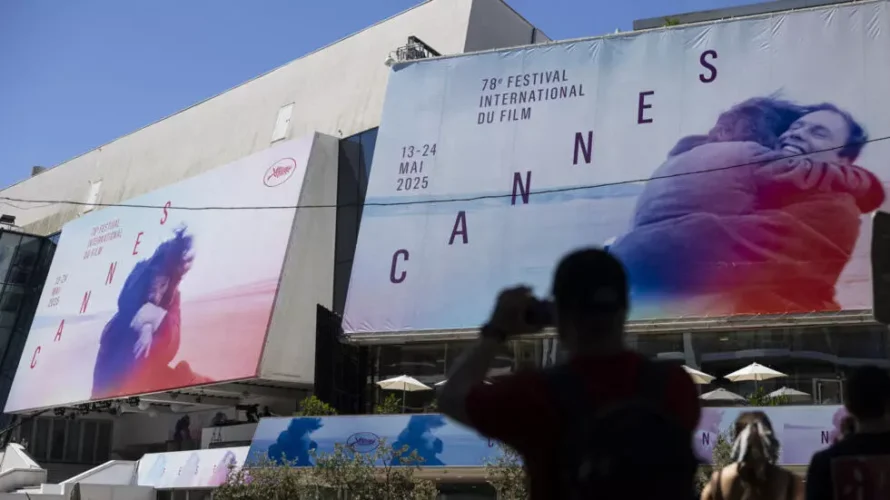 5月12日、第78回カンヌ映画祭の前夜、歩行者がパレ・デ・フェスティバルの外で写真を撮る。AFP - サミール・アル=ドゥミー