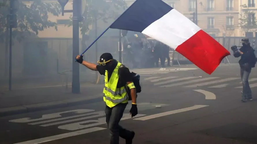 パリでのメーデー集会で、抗議者がフランス国旗を振る。パリでは、休日の労働規則をめぐる緊張が政治的な議論を巻き起こしている。AP - フランソワ・モリ