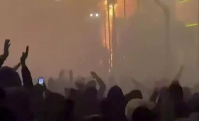 この画像は、1月9日にソーシャルメディアに投稿された動画からのもので、イラン・テヘランで放火された建物の前にいる抗議者を映しています。© UGC/AFO