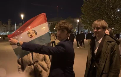 ハンガリーの旗を掲げた学生たち――それは共産主義を終わらせた1989年の革命を思い起こさせ、人々は旗からソビエトの紋章を切り取っています。ブダペスト、2026年4月12日。© RFI/Jan van der Made