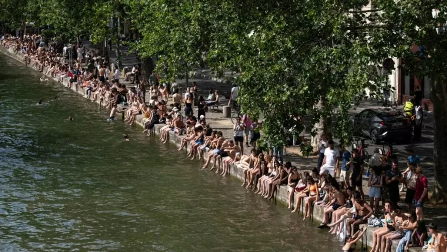 フランス全土で気温が上昇するにつれ、人々は川や湖、運河で泳ぐことに時が好まっており、パリ東部のサン=マルタン運河でも同様に見られます。当局は、許可されていない場所で泳がないよう警告しています。© Arnaud Finistre/AFP